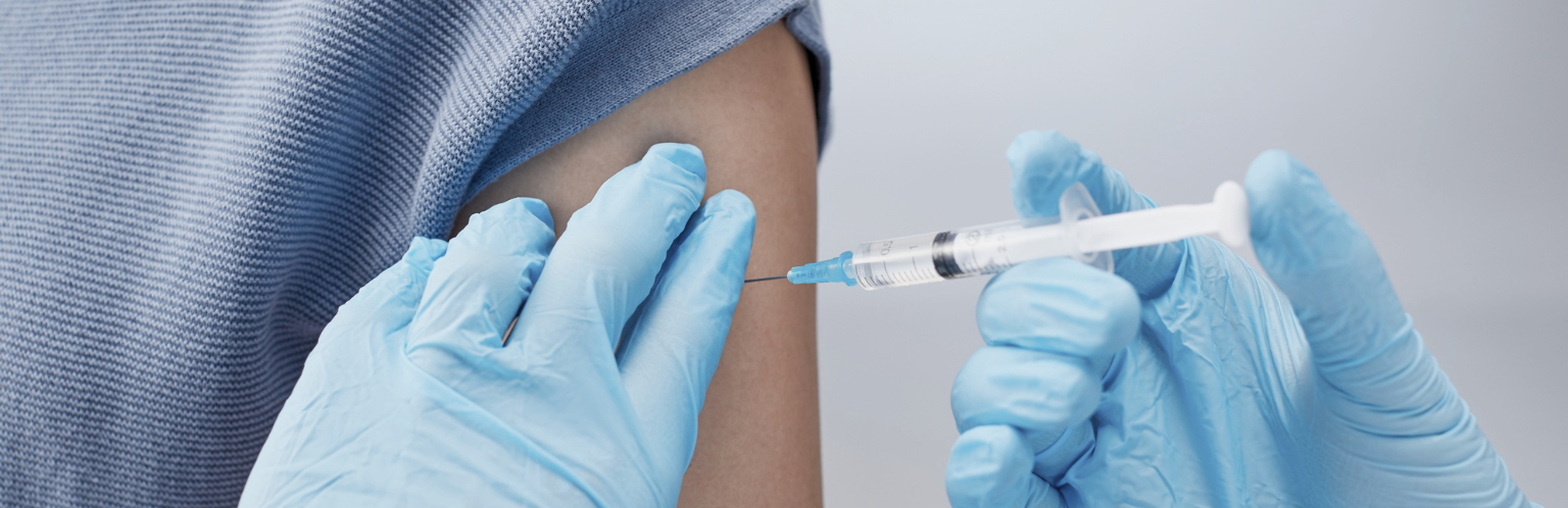 Person recieving a shot from medical personnel.
